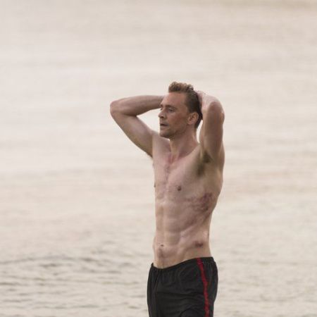 A shirtless Tom Hiddleston showing his abs